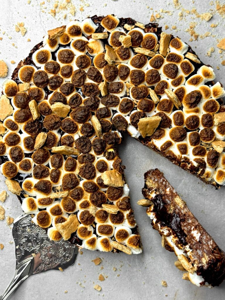 Gâteau avec une base de Rice Krispies, une ganache au chocolat, des guimauves grillées et des biscuits Graham.
